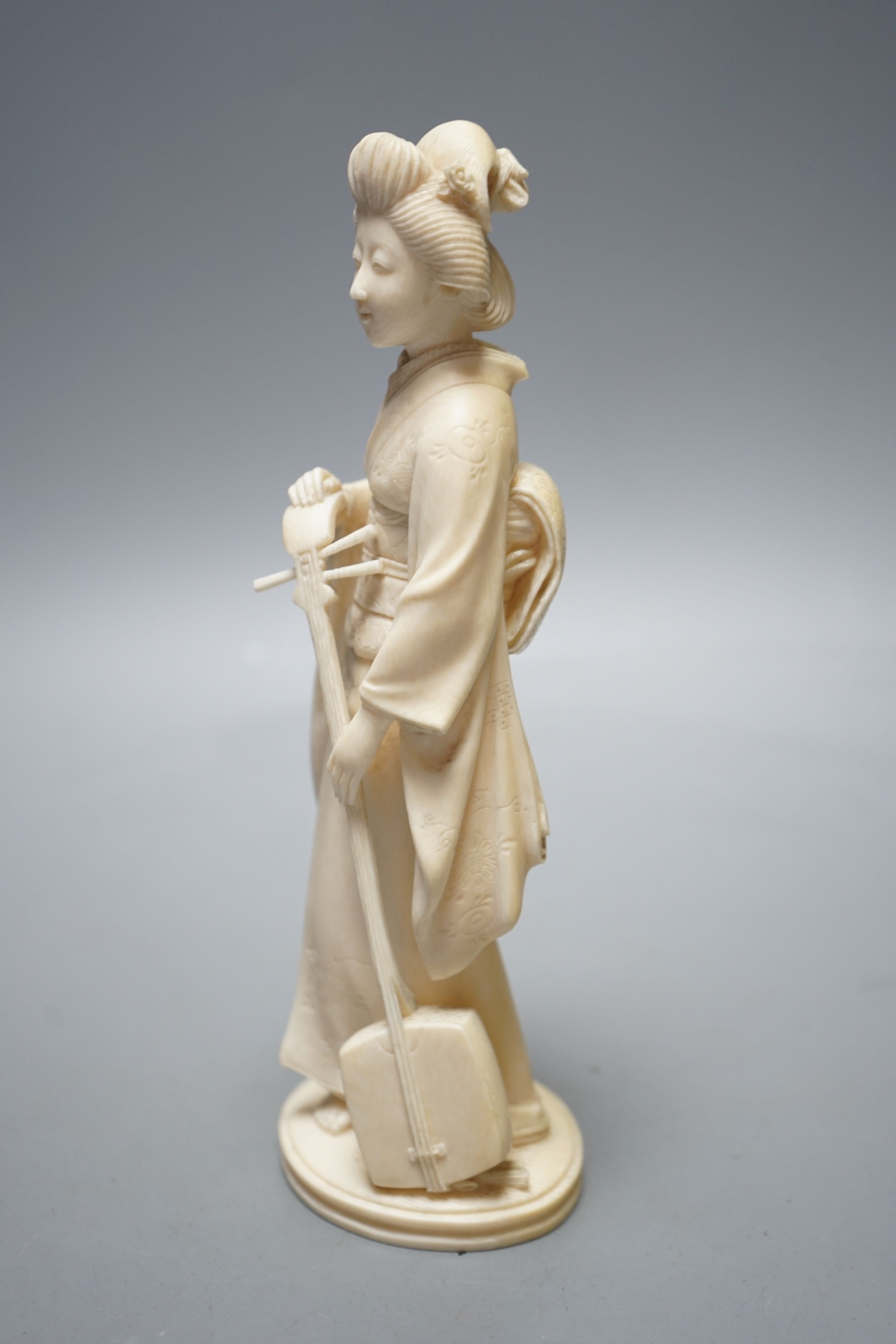 A Japanese Meiji period okimono of a lady with a musical instrument, 19 cms high.